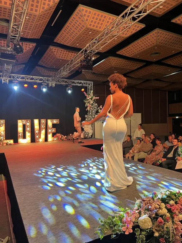 Mannequin en robe de mariée avec bouquet Jantzen Fleurs au défilé du Salon du mariage